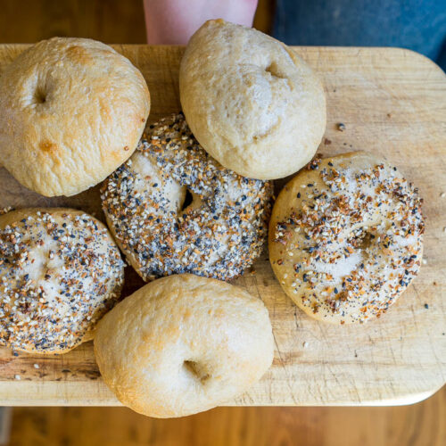 sourdough bagels on a wooden cutting board