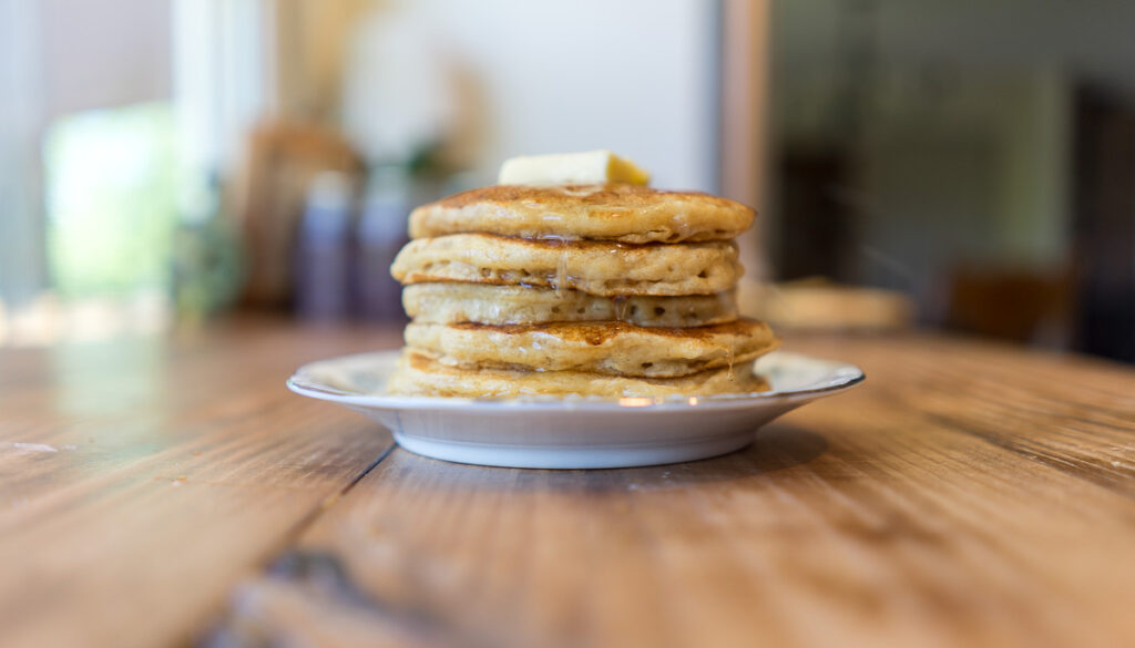 stack of fresh-milled sourdough protein pancakes on a wooden counter